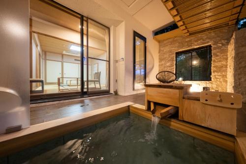 a bathroom with a pool and a sink and a mirror at 伊豆高原温泉ホテル 森の泉 in Ito