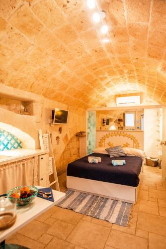 a bedroom with a bed in a stone walled room at Casa Monopolina in Monopoli