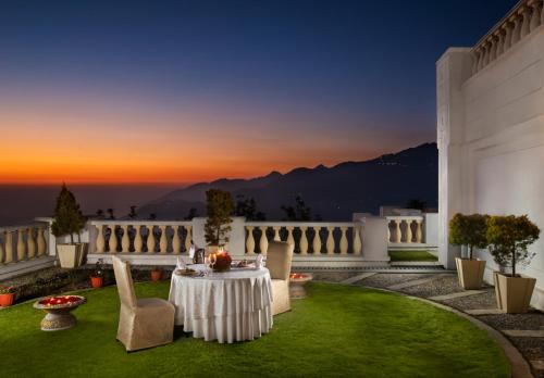 a patio with a table and chairs on a lawn at Jaypee Residency Manor in Mussoorie