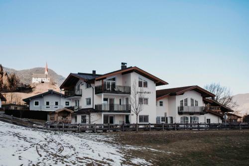 a large white house with snow on the ground at Green Apart in Uderns