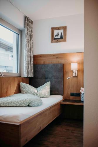 a bedroom with a wooden bed with a window at Green Apart in Uderns
