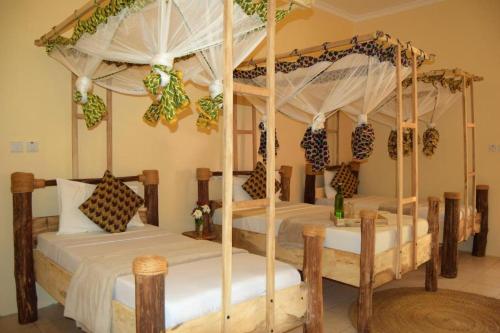 two twin beds in a room with at Chanya Lodge in Moshi