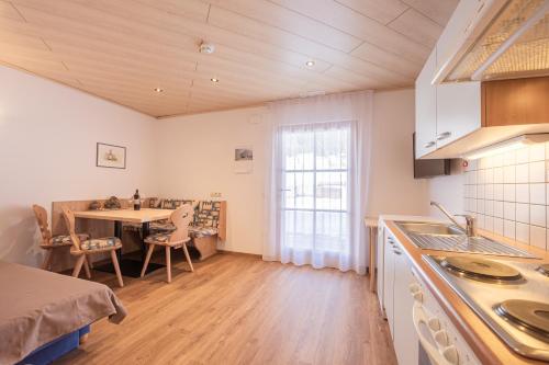 a kitchen with a table and a dining room at Residence Alpina in Santa Maddalena in Casies