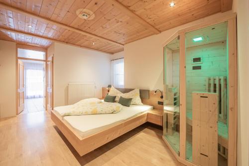 a bedroom with a bed and a glass wall at Residence Alpina in Santa Maddalena in Casies