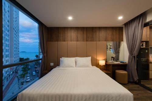 a bedroom with a large bed and a large window at The Anchor Apartment - Nha Trang in Nha Trang