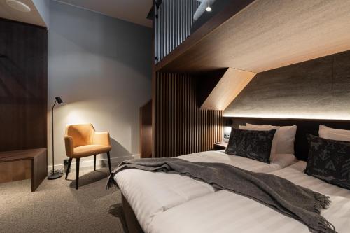 a bedroom with a large bed and a chair at Lapland Hotels Arena in Tampere