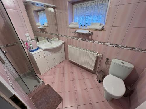 a pink bathroom with a toilet and a sink at Apartament ESSA Karpacz - 1 in Karpacz