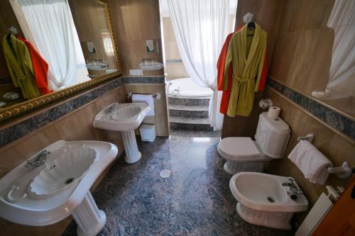 a bathroom with two sinks and two toilets at Hotel Flor de la Mancha in La Roda