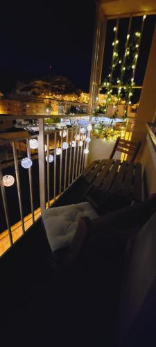 a balcony with chairs and a view of a city at night at ALMERIA SOL Y SUR APARTMENTO - Netflix y Parking GRATUITO in Almería
