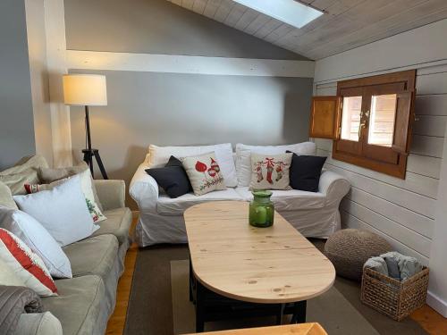 a living room with a couch and a table at Acogedora Buardilla duplex 6 pax in Incles