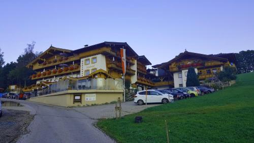 a yellow building with cars parked in a parking lot at Gasthof Schöntal in Oberau