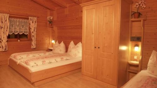 a bedroom with a bed in a wooden room at Appartement Bergrose in Hopfgarten im Brixental