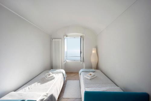 ein kleines Zimmer mit 2 Betten und einem Fenster in der Unterkunft Old city apartment seaview in Bordighera