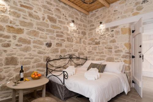 um quarto com uma cama numa parede de pedra em Physis Country House near Matala beach & Faistos em Kousés
