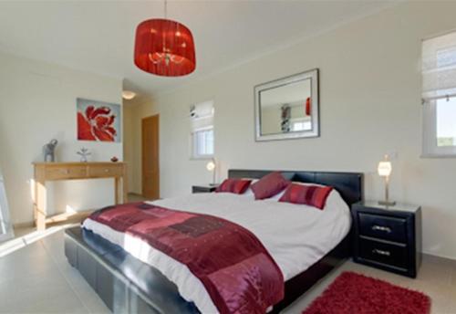 阿亞蒙特的住宿－5 Bedroom Villa Pool and Garden，一间卧室配有一张带红色枕头的大床