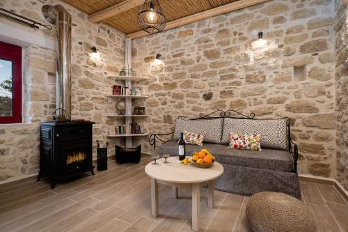 a living room with a couch and a stove at Physis Country House near Matala beach & Faistos in Kousés