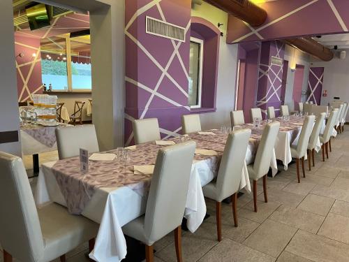 a dining room with tables and chairs and purple walls at Hotel Cascina Marisa in Opera