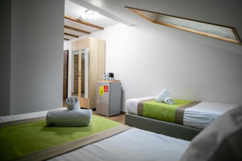 Una habitación con dos camas y una pequeña nevera. en Crema Residence, en Alba Iulia