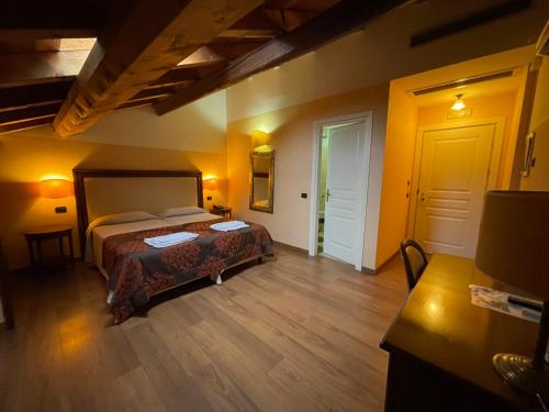 um quarto com uma cama num quarto com paredes amarelas em Hotel Cascina Marisa em Opera