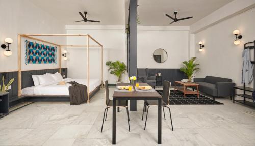 um quarto com uma cama, uma mesa e cadeiras em Poshtel VNS em Varanasi