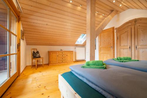 two beds in a room with a wooden ceiling at Ferienwohnung Bergluft in Mittenwald