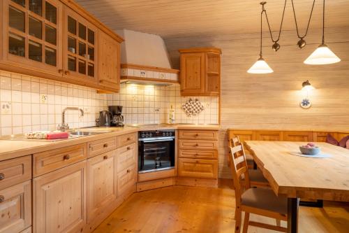 a kitchen with wooden cabinets and a wooden dining table at Ferienwohnung Bergluft in Mittenwald