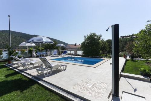 a villa with a swimming pool and patio furniture at Villa Celenca in Mokošica