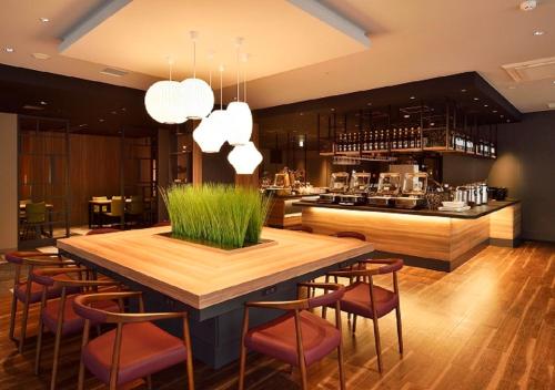 a dining room with a table and chairs and a kitchen at Tokyu Stay Sapporo Odori in Sapporo