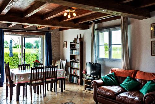 a living room with a couch and a table and chairs at Les Gîtes de Brives in Brives-sur-Charente