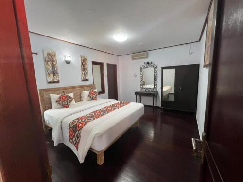 a bedroom with a large bed and a mirror at Wikarmas Villa Sanur in Sanur