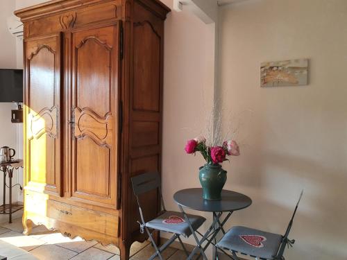una habitación con una mesa con un jarrón de flores en la réveuse en Gordes