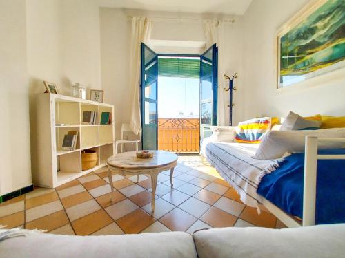 ein Wohnzimmer mit einem Sofa und einem Tisch in der Unterkunft APARTAMENTO SUITE ALAMEDA-CALATRAVA. in Sevilla