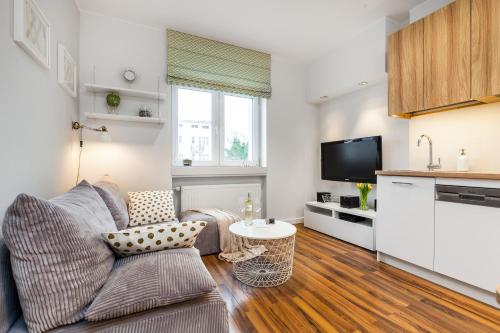 a living room with a couch and a table at Apartamenty Black&White in Gdynia