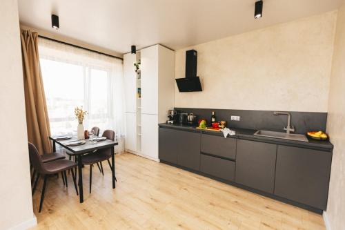 a kitchen with a table and a dining room at NUDE Просторі апартаменти біля історичного центру вул.Збаразька in Ternopilʼ