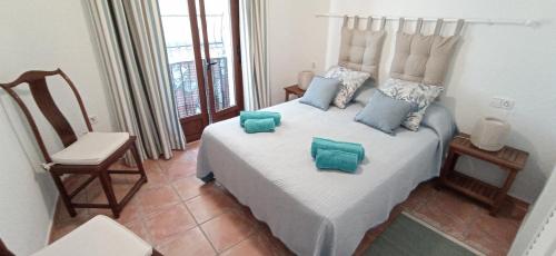 - une chambre avec un grand lit blanc et des oreillers bleus dans l'établissement Apartamento Neptuno, comodo, mediterraneo, centro historico, reformado recientemente y cercano a la playa, à La Vila Joiosa