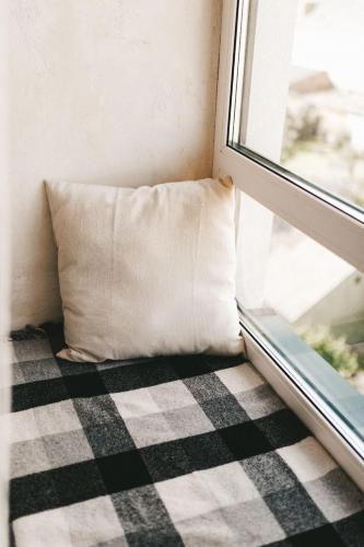 a pillow sitting on the floor next to a window at NUDE Просторі апартаменти біля історичного центру вул.Збаразька in Ternopilʼ