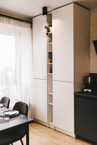 a kitchen with a white cabinet and a table at NUDE Просторі апартаменти біля історичного центру вул.Збаразька in Ternopilʼ