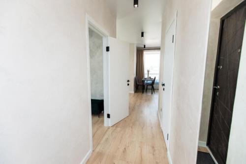 an empty hallway with white walls and wooden floors at NUDE Просторі апартаменти біля історичного центру вул.Збаразька in Ternopilʼ