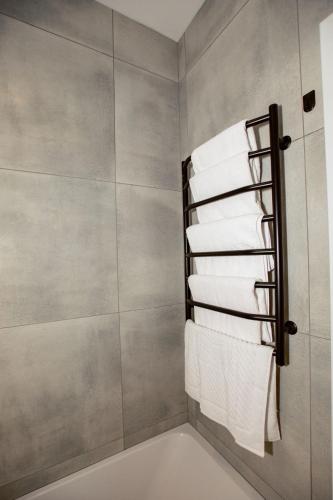 a bathroom with a towel rack with white towels at NUDE Просторі апартаменти біля історичного центру вул.Збаразька in Ternopilʼ