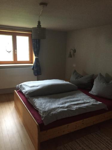 a bed sitting in a room with a window at Waldeslust in Weiler-Simmerberg