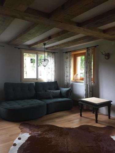 a living room with a blue couch and a table at Waldeslust in Weiler-Simmerberg