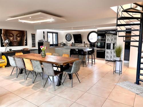 une cuisine et une salle à manger avec une table et des chaises en bois dans l'établissement Villa du Sieck 5 étoiles, à Santec