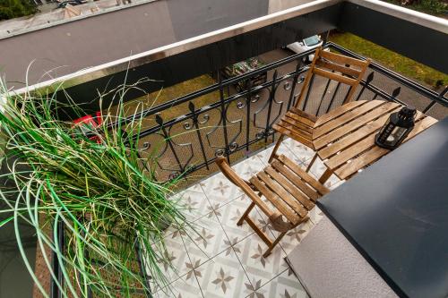 a balcony with a bench and a table and a plant at Apartamenty Black&White in Gdynia