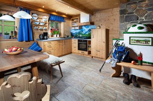 a kitchen with a table and a stone wall at Ettlerlehen Chalets in Ramsau