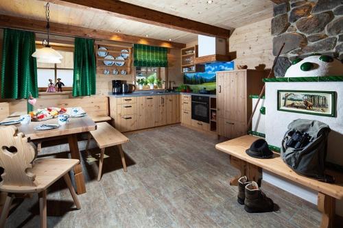 a large kitchen with wooden tables and a dining room at Ettlerlehen Chalets in Ramsau