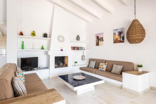 a living room with a couch and a table at Villa BiniRe by 3VILLAS in Binibeca
