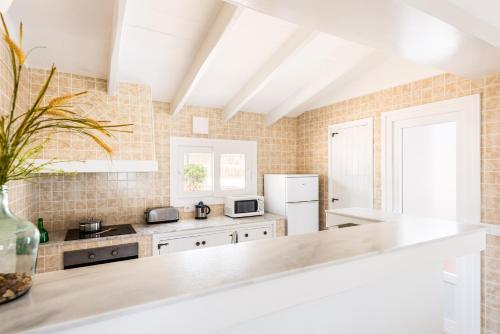 a kitchen with white appliances and a counter top at Villa BiniRe in Binibeca
