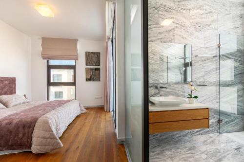 um quarto com uma cama e uma casa de banho com um lavatório em Villa Beach Heaven(Laurus 1), walking distance to the beach em Paphos