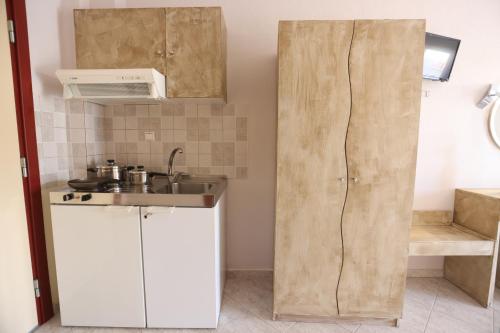 a small kitchen with a sink and a refrigerator at Summer Dream Hotel in Polykhrono