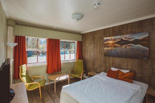 um quarto com uma cama, uma mesa e cadeiras em Saltdal Turistsenter em Storjord